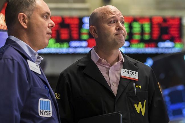 In this photo provided by the New York Stock Exchange, Thomas Warshaw, left, and Jay Woods work on the trading floor, Thursday, Feb. 24, 2022. Markets shuddered worldwide Thursday and swung sharply after Russia's invasion of Ukraine threatened to push the high inflation squeezing the global economy even higher. (Courtney Crow/New York Stock Exchange via AP)