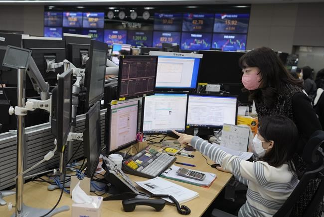 Currency traders watch monitors at the foreign exchange dealing room of the KEB Hana Bank headquarters in Seoul, South Korea, Friday, Feb. 25, 2022. Asian shares rose Friday after U.S. stocks recovered toward the end of a wild trading day, as the world, including President Joe Biden, slapped sanctions against Russia for its invasion of Ukraine. (AP Photo/Ahn Young-joon)