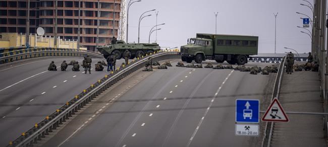 Ukrainian soldiers take position on a bridge inside the city of Kyiv, Ukraine, Friday, Feb. 25, 2022. Russia pressed its invasion of Ukraine to the outskirts of the capital Friday after unleashing airstrikes on cities and military bases and sending in troops and tanks from three sides in an attack that could rewrite the global post-Cold War security order. (AP Photo/Emilio Morenatti)