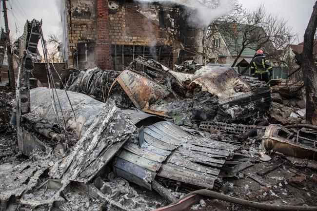 A Ukrainian firefighter walks between at fragments of a downed aircraft seen in in Kyiv, Ukraine, Friday, Feb. 25, 2022. It was unclear what aicraft crashed and what brought it down amid the Russian invasion in Ukraine Russia is pressing its invasion of Ukraine to the outskirts of the capital after unleashing airstrikes on cities and military bases and sending in troops and tanks from three sides. (AP Photo/Oleksandr Ratushniak)