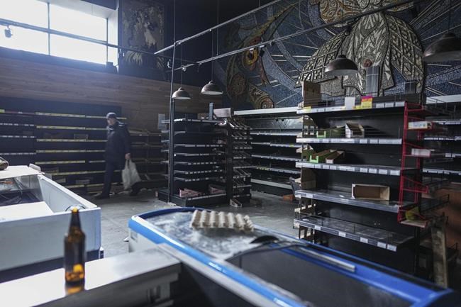 A man walks in an abandoned supermarket in Mariupol, Ukraine, Sunday, March 6, 2022. (AP Photo/Evgeniy Maloletka)