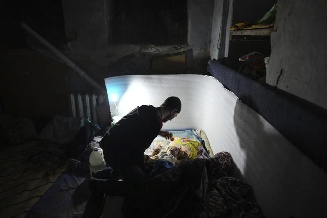 A man plays with a baby in a bomb shelter in Mariupol, Ukraine, Sunday, March 6, 2022. (AP Photo/Evgeniy Maloletka)