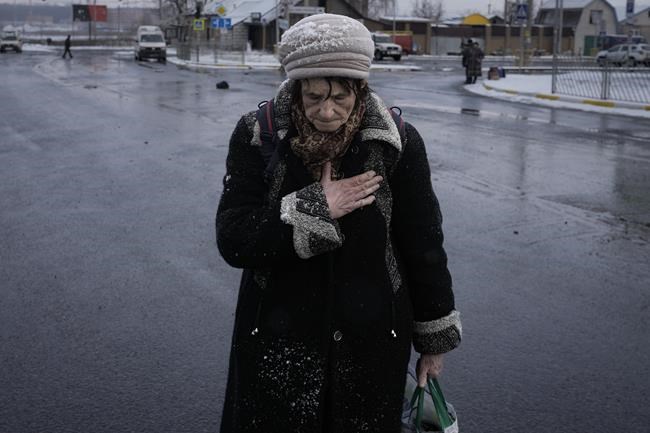 An elderly lady pauses after fleeing Irpin, on the outskirts of Kyiv, Ukraine, Tuesday, March 8, 2022. Demands for ways to safety evacuate civilians have surged along with intensifying shelling by Russian forces, who have made significant advances in southern Ukraine but stalled in some other regions. Efforts to put in place cease-fires along humanitarian corridors have repeatedly failed amid Russian shelling.(AP Photo/Vadim Ghirda)