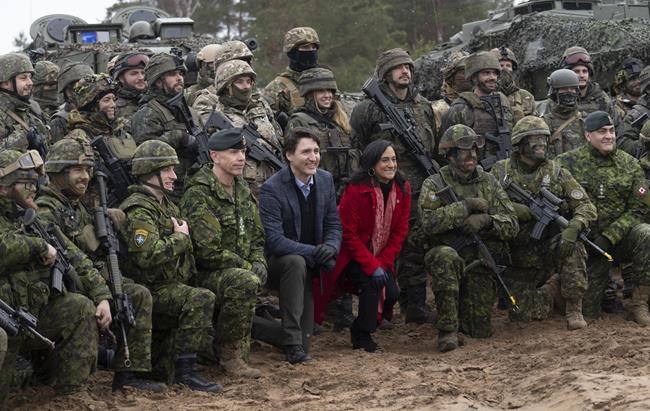 Canadian Prime Minister Justin Trudeau and Minister of Defence Anita Anand pose with soldiers deployed as part of Operation Reassurance as they visits the Adazi Military basein Adazi, Latvia, Tuesday, March 8, 2022. THE CANADIAN PRESS/Adrian Wyld