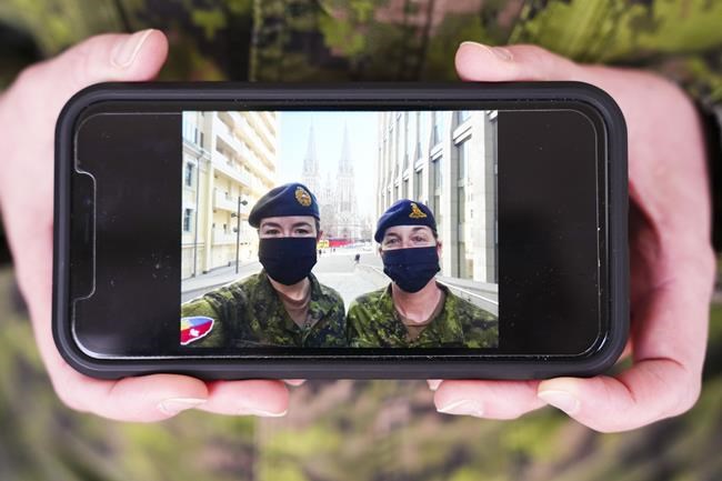 Lt.-Col. Sarah Heer holds a picture in Ottawa on Tuesday, March 8, 2022, of herself, right, and Lt.-Col. Melanie Lake, taken in Kyiv, Ukraine, in 2021 during a rotational handover. Heer has been dealing with a range of emotions over the past two weeks: fear, worry and more than a little pride as she has watched her former students defend their country.THE CANADIAN PRESS/Sean Kilpatrick