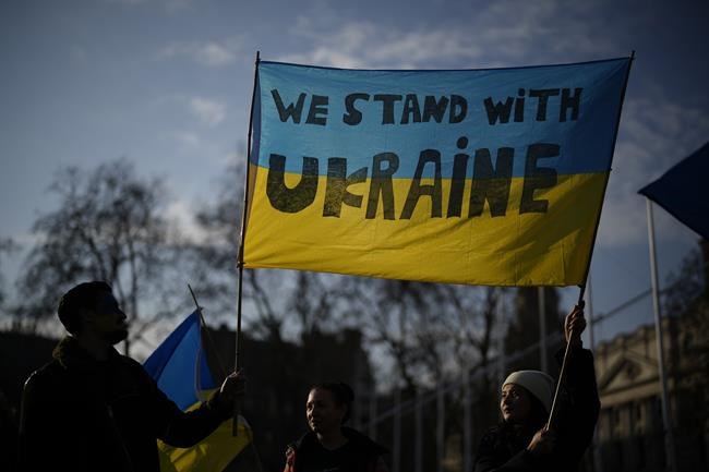 People from the BrightLocal SEO (Search Engine Optimization) company protest against the Russian invasion of Ukraine in solidarity with their software engineer colleagues who are from and based in Ukraine, on Parliament Square, opposite the Houses of Parliament, in London, Tuesday, March 8, 2022. The humanitarian crisis in Ukraine is deepening with food, water and medicine growing increasingly scarce as Russian forces intensify their shelling. (AP Photo/Matt Dunham)