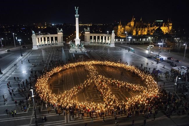 People create a peace sign with lights as a demonstration for Ukraine at Heroes Square in Budapest, Hungary organised by Greenpeace, Wednesday, March 9, 2022. Russia's invasion of Ukraine has set off the largest mass migration in Europe in decades, with more than 1.5 million people having crossed from Ukraine into neighbouring countries. (AP Photo/Anna Szilagyi)
