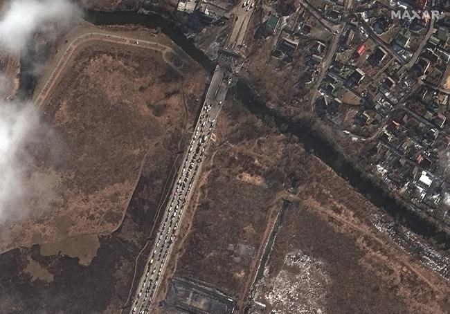 This satellite image provided by Maxar Technologies shows a long line of people and cars waiting by the damaged Irpin River bridge during the Russian invasion, in Irpin, Ukraine, Thursday, March 10, 2022. (Satellite image ©2022 Maxar Technologies via AP)