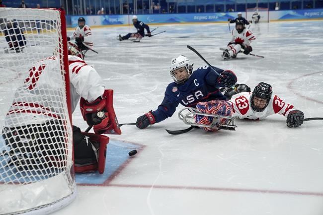 Josh Pauls of the U.S.A. and Garrett Riley of Canada collide during the Para Ice Hockey Gold Medal Game between the United States and Canada at the National Indoor Stadium during the Beijing 2022 Winter Paralympic Games in Beijing, China, Sunday, March 13, 2022. THE CANADIAN PRESS/AP-Bob Martin/OIS via AP