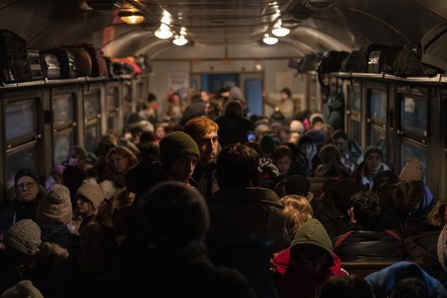 Displaced Ukrainians onboard a Poland bound train in Lviv, western Ukraine, Sunday, March 13, 2022. Lviv in western Ukraine itself so far has been spared the scale of destruction unfolding to its east and south. The city's population of 721,000 has swelled during the war with residents escaping bombarded population centers and as a waystation for the nearly 2.6 million people who have fled the country. (AP Photo/Bernat Armangue)