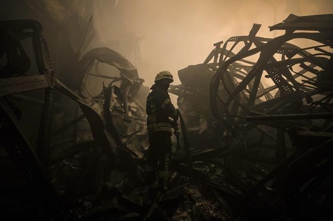 A Ukrainian firefighter drags a hose inside a large food products storage facility which was destroyed by an airstrike in the early morning hours on the outskirts of Kyiv, Ukraine, Sunday, March 13, 2022. Waves of Russian missiles pounded a military training base close to Ukraine's western border with NATO member Poland, killing 35 people, following Russian threats to target foreign weapon shipments that are helping Ukrainian fighters defend their country against Russia's grinding invasion.(AP Photo/Vadim Ghirda)