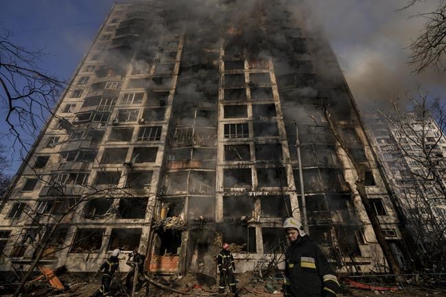 Firefighters work outside a destroyed apartment building after a bombing in a residential area in Kyiv, Ukraine, Tuesday, March 15, 2022. Russia's offensive in Ukraine has edged closer to central Kyiv with a series of strikes hitting a residential neighborhood as the leaders of three European Union member countries planned a visit to Ukraine's embattled capital. (AP Photo/Vadim Ghirda)
