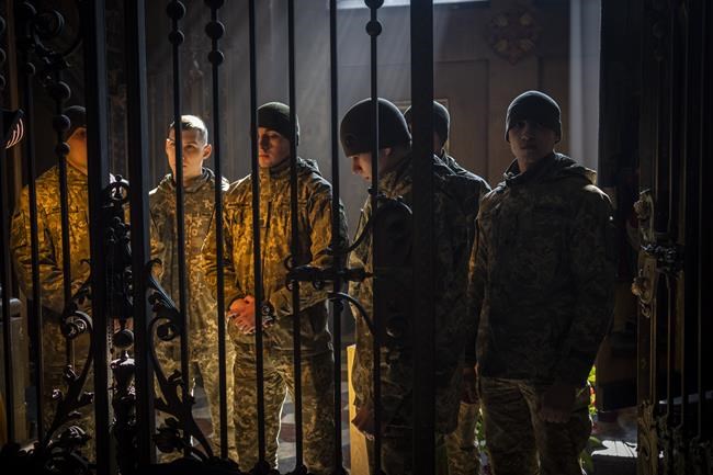 Military cadets attend a funeral ceremony for four of the Ukrainian military servicemen, who were killed during an airstrike in a military base in Yavoriv, in a church in Lviv, Ukraine, Tuesday, March 15, 2022. At least 35 people were killed and many wounded in Sunday's Russian missile strike on a military training base near Ukraine's western border with NATO member Poland. (AP Photo/Bernat Armangue)