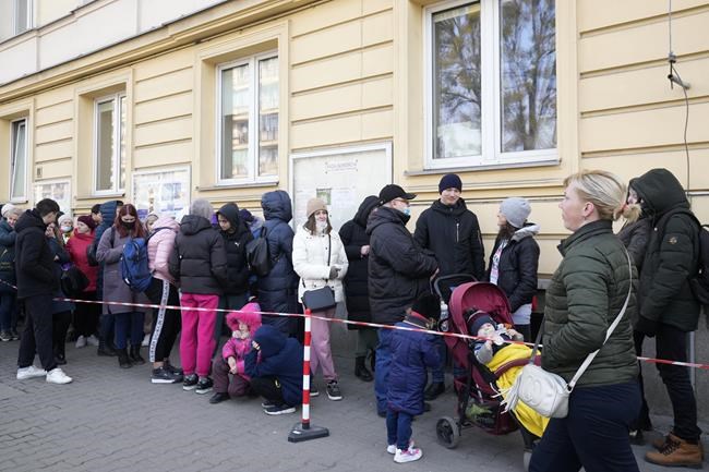 Ukrainians stand in line to apply for a national identity number in Warsaw, Poland, Wednesday March 16, 2022. Wednesday was the first day that Ukrainian refugees who fled the war at home were allowed to apply for a Polish ID number which will give them access to public services such as medical care and education. (AP Photo/Czarek Sokolowski)