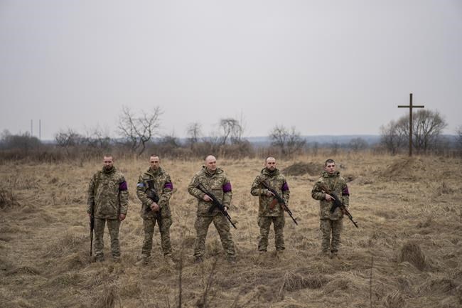 Ukrainian military servicemen prepare to fire salutes during the funeral of their comrades, Roman Rak and Mykola Mykytiuk, in Starychi, western Ukraine, Wednesday, March 16, 2022. Rak and Mykytiu were killed during Sunday's Russian missile strike on a military training base in Yavoriv. (AP Photo/Bernat Armangue)