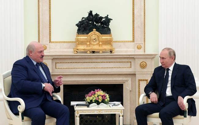 Belarusian President Alexander Lukashenko, left, and Russian President Vladimir Putin speak to each other during their meeting in Moscow, Russia, Friday, March 11, 2022. (Mikhail Klimentyev, Sputnik, Kremlin Pool Photo via AP)