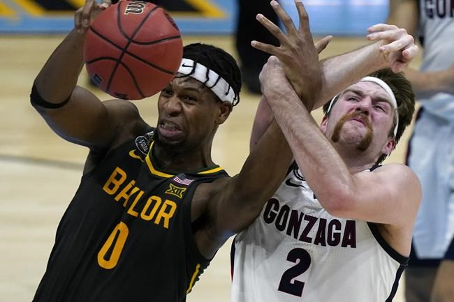 FILE -Baylor forward Flo Thamba (0) fights for a rebound with Gonzaga forward Drew Timme (2) during the first half of the championship game in the men's Final Four NCAA college basketball tournament, Monday, April 5, 2021, at Lucas Oil Stadium in Indianapolis. Thamba, who has a 7-foot-5 wingspan, is originally from the Democratic Republic of the Congo, grew up in South Africa and also lived in England and France before coming to the United States. He looks forward to having his parents in the stands while playing on the biggest stage. (AP Photo/Michael Conroy, File)