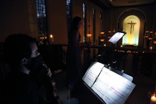 Violinist Michael Ferri, left, accompanies mezzo-soprano Karolina Wojteczko in a performance of traditional Ukrainian chants and folk songs during a benefit concert for Ukraine at St. Thomas More Catholic chapel in New Haven, Conn., Wednesday, March 16, 2022. Wojteczko, a native of Poland, was inspired to organize the concert by the distress she has noticed among both Eastern European and American friends. (AP Photo/Jessie Wardarski)