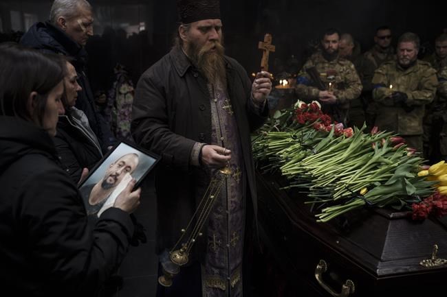 Family members and Ukrainian servicemen attend the funeral ceremony of marine Alexandr Khovtun, in Kyiv, Ukraine, Sunday, March 20, 2022. Khovtun died in combat in the town of Huta-Mezhyhirska, north of Kyiv. (AP Photo/Felipe Dana)