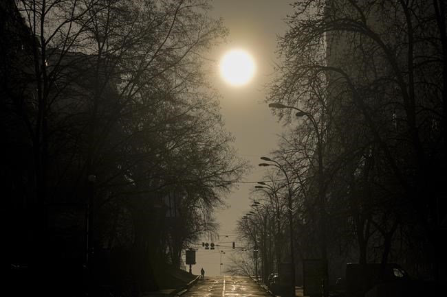 A woman walks on a deserted street in Kyiv, Ukraine, Monday, March 21, 2022. As Russia intensified its effort to pound Mariupol into submission, its ground offensive in other parts of Ukraine has become bogged down. Western officials and analysts say the conflict is turning into a grinding war of attrition, with Russia bombarding cities. (AP Photo/Vadim Ghirda)