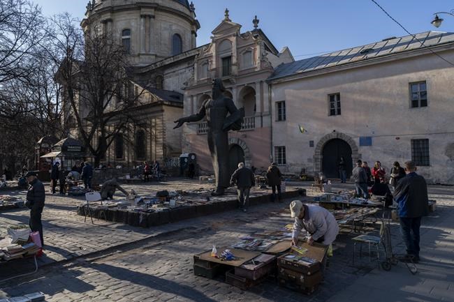 People roam around a used-books street market in downtown Lviv, western Ukraine, Tuesday, March 22, 2022. The U.N. refugee agency says more than 3.5 million people have fled Ukraine since Russia's invasion, passing another milestone in an exodus that has led to Europe's worst refugee crisis since World War II. (AP Photo/Bernat Armangue)