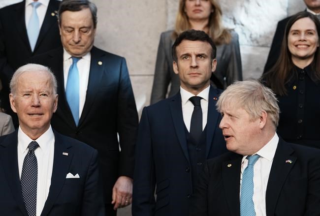 British Prime Minister Boris Johnson, front right, looks toward U.S. President Joe Biden, front left, at a group photo during an extraordinary NATO summit at NATO headquarters in Brussels, Thursday, March 24, 2022. As the war in Ukraine grinds into a second month, President Joe Biden and Western allies are gathering to chart a path to ramp up pressure on Russian President Vladimir Putin while tending to the economic and security fallout that's spreading across Europe and the world. (AP Photo/Thibault Camus)