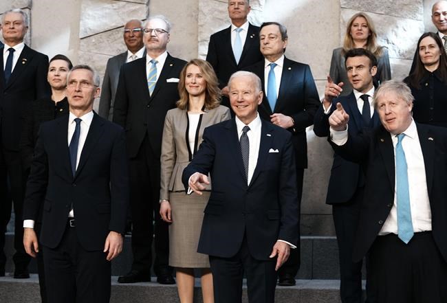 NATO Secretary General Jens Stoltenberg, center front left, U.S. President Joe Biden, center front, and British Prime Minister Boris Johnson, front right, pose during a group photo during an extraordinary NATO summit at NATO headquarters in Brussels, Thursday, March 24, 2022. As the war in Ukraine grinds into a second month, President Joe Biden and Western allies are gathering to chart a path to ramp up pressure on Russian President Vladimir Putin while tending to the economic and security fallout that's spreading across Europe and the world. (AP Photo/Thibault Camus)