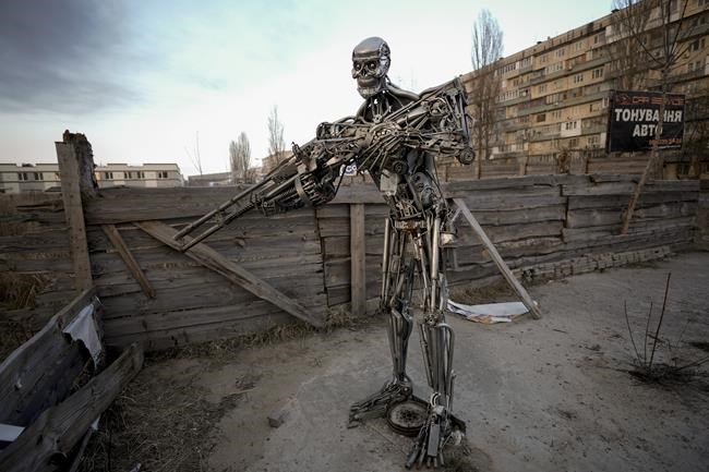 A depictions of the Terminator, made from automobile transmission parts, is placed near a checkpoint in Kyiv, Ukraine, Friday, March 25, 2022. About 300 people were killed in the Russian airstrike last week on a Mariupol theater that was being used as a shelter, Ukrainian authorities said Friday in what would make it the war's deadliest known attack on civilians yet.(AP Photo/Vadim Ghirda)