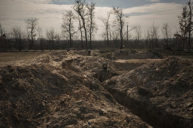Ukrainian servicemen stand in trenches at a position north of the capital Kyiv, Ukraine, Tuesday, March 29, 2022. The first face-to-face talks in two weeks between Russia and Ukraine began Tuesday in Turkey, raising flickering hopes there could be progress toward ending a war that has ground into a bloody campaign of attrition. (AP Photo/Vadim Ghirda)