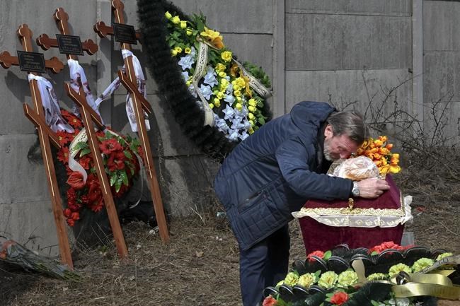 A relative mourns on the coffin with the body of 3 year-old Mykola Goryainiv, who died with his parents as they were driving a car trying to evacuate from a fighting zone in Kharkiv region, during a funeral ceremony in Kramatorsk, Ukraine, Wednesday, March 30, 2022. (AP Photo/Andriy Andriyenko)