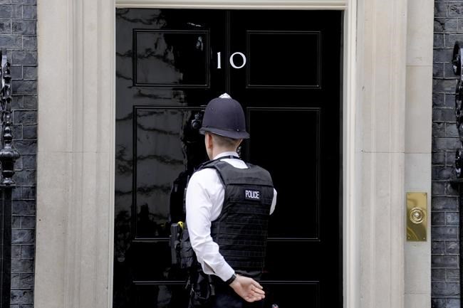 A police officer knocks on the door of 10 Downing Street in London, Tuesday, April 12, 2022. U.K. Prime Minister Boris Johnson's office says he will be issued a fine for breaching COVID-19 regulations following allegations of lockdown parties at government offices. Treasury Chief Rishi Sunak will also be fined. (AP Photo/Kirsty Wigglesworth)
