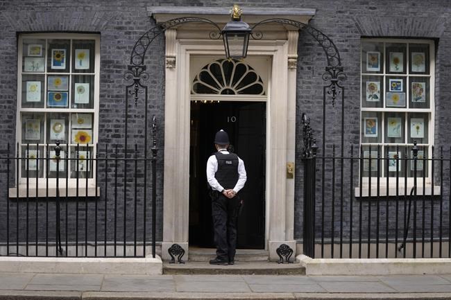 A police officer knocks on the door of 10 Downing Street in London, Tuesday, April 12, 2022. U.K. Prime Minister Boris Johnson's office says he will be issued a fine for breaching COVID-19 regulations following allegations of lockdown parties at government offices. Treasury Chief Rishi Sunak will also be fined. (AP Photo/Kirsty Wigglesworth)