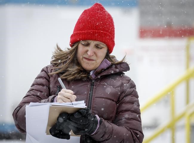 Deputy Prime Minister Chrystia Freeland makes notes before speaking to the media after visiting a research and development facility in Calgary, Thursday, April 14, 2022. Freeland says Canada is committed to seeking justice for Ukrainian women and children as allegations mount of sexual violence by Russian soldiers. THE CANADIAN PRESS/Jeff McIntosh
