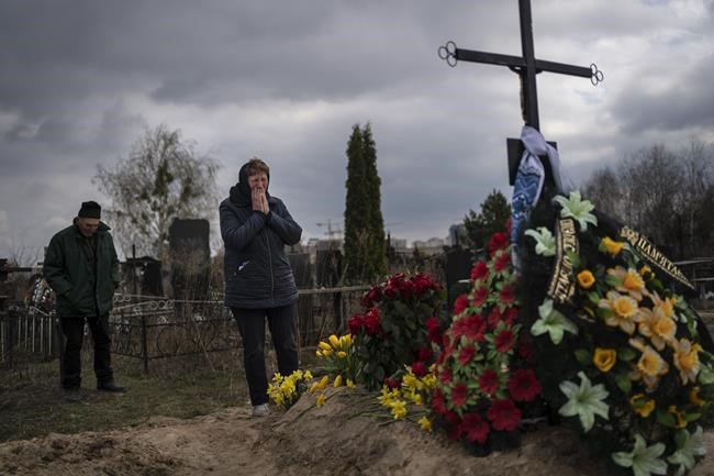 Galyna Bondar, mourns next to the grave of her son Oleksandr, 32, after burying him at the cemetery in Bucha, on the outskirts of Kyiv, Ukraine on Saturday, April 16, 2022. Oleksandr, who joined the territorial Ukrainian defence as a co-ordinator was killed by a gunshot by the Russian Army. (AP Photo/Rodrigo Abd)