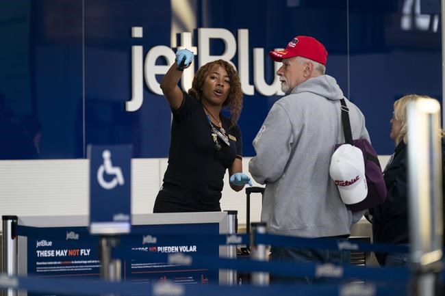 Passengers check in at the terminal at Ronald Reagan Washington National Airport, Tuesday, April 19, 2022, in Arlington, Va. A federal judge's decision to strike down a national mask mandate was met with cheers on some airplanes but also concern about whether it's really time to end the order sparked by the COVID-19 pandemic. (AP Photo/Evan Vucci)
