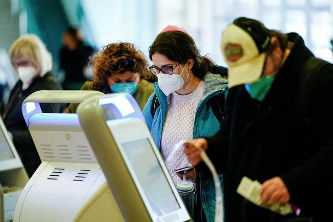 Travelers wearing protective masks as a precaution against the spread of the coronavirus check in at the Philadelphia International Airport in Philadelphia, Tuesday, April 19, 2022. A federal judge's decision to strike down a national mask mandate was met with cheers on some airplanes but also concern about whether it's really time to end one of the most visible vestiges of the COVID-19 pandemic. (AP Photo/Matt Rourke)