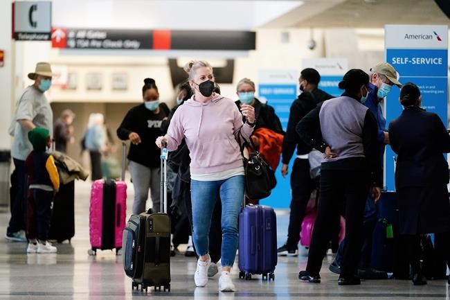 Travelers wearing protective masks as a precaution against the spread of the coronavirus move about the a terminal at the Philadelphia International Airport in Philadelphia, Tuesday, April 19, 2022. A federal judge's decision to strike down a national mask mandate was met with cheers on some airplanes but also concern about whether it's really time to end one of the most visible vestiges of the COVID-19 pandemic. (AP Photo/Matt Rourke)