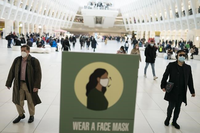 Mass transit riders wear masks as they commute in the financial district of lower Manhattan, Tuesday, April 19, 2022, in New York. U.S. District Judge Kathryn Kimball Mizelle in Tampa, Fla., on April 18, 2022, voided the national travel mask mandate as exceeding the authority of U.S. health officials. The mask mandate that covers travel on airplanes and other public transportation was recently extended by President Joe Biden's administration until May 3. (AP Photo/John Minchillo)