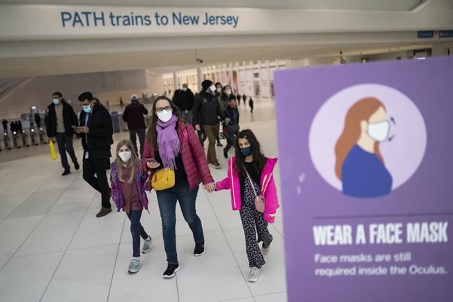Mass transit riders wear masks as they commute in the financial district of lower Manhattan, Tuesday, April 19, 2022, in New York. U.S. District Judge Kathryn Kimball Mizelle in Tampa, Fla., on April 18, 2022, voided the national travel mask mandate as exceeding the authority of U.S. health officials. The mask mandate that covers travel on airplanes and other public transportation was recently extended by President Joe Biden's administration until May 3. (AP Photo/John Minchillo)