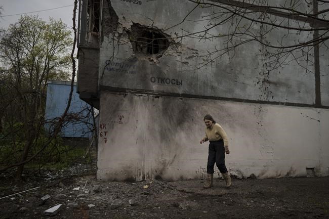 A woman walks next to a damaged building after a Russian bombardment in Kharkiv, Ukraine, Tuesday, April 19, 2022. Russia ratcheted up its battle for control of Ukraine’s eastern industrial heartland on Tuesday, intensifying assaults on cities and towns along a front hundreds of miles long in what officials on both sides described as a new phase of the war. (AP Photo/Felipe Dana)