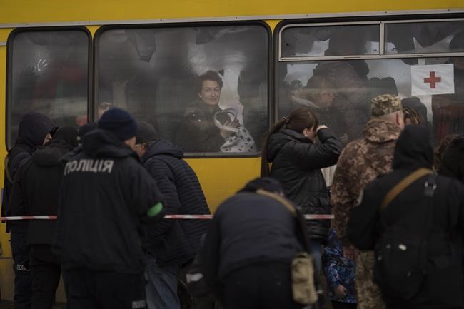 An internally displaced woman looks out of a bus window after arriving from Mariupol at a refugee center fleeing from the Russian attacks, in Zaporizhzhia, Ukraine, Thursday, April 21, 2022. Mariupol, which is part of the industrial region in eastern Ukraine known as the Donbas, has been a key Russian objective since the Feb. 24 invasion began. (AP Photo/Leo Correa)