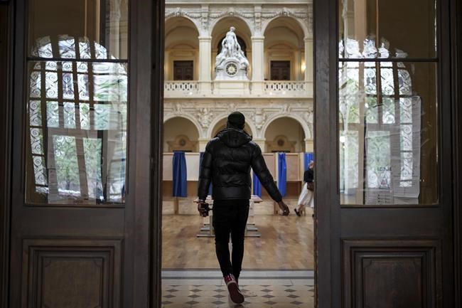A man arrives at a the polling station to vote in the second round of the French presidential election in Lyon, central France, Sunday, April 24, 2022. France began voting in a presidential runoff election with repercussions for Europe's future, with centrist incumbent Emmanuel Macron the front-runner but fighting a tough challenge from far-right rival Marine Le Pen. (AP Photo/Laurent Cipriani)