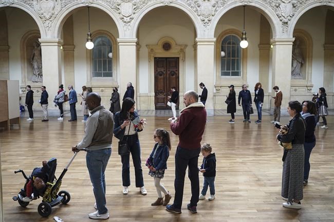 People queue to vote at a polling station in Lyon, central France, Sunday, April 24, 2022. France began voting in a presidential runoff election with repercussions for Europe's future, with centrist incumbent Emmanuel Macron the front-runner but fighting a tough challenge from far-right rival Marine Le Pen. (AP Photo/Laurent Cipriani)