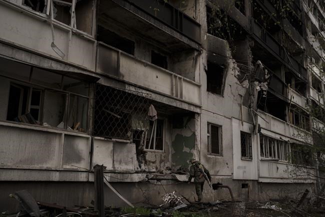 A Ukrainian serviceman inspects a heavily damaged apartment building after Russian bombardment in Kharkiv, Ukraine, Sunday, April 24, 2022. (AP Photo/Felipe Dana)