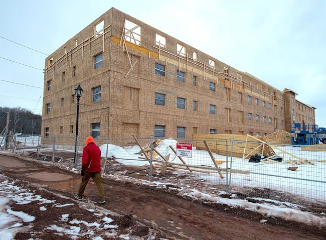 A man walks past an affordable housing complex being constructed in Charlottetown's Hillsborough Park area, on Saturday, Feb. 29, 2020. About $7.9 million from the federal government will go toward building affordable housing in Charlottetown. THE CANADIAN PRESS/Andrew Vaughan