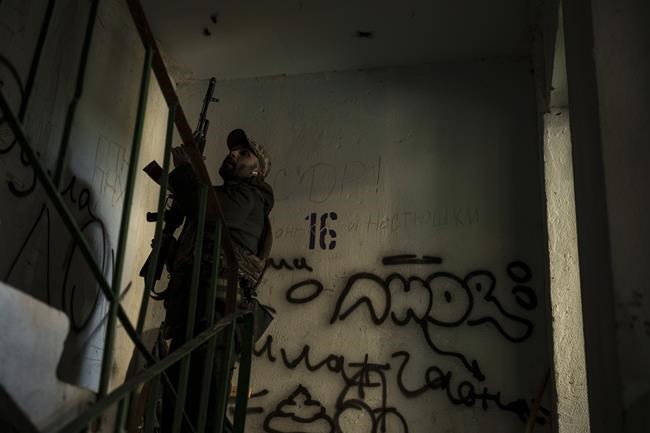 A Ukrainian serviceman walks in a building near a frontline position in Kharkiv, Ukraine, Monday, April 25, 2022. (AP Photo/Felipe Dana)