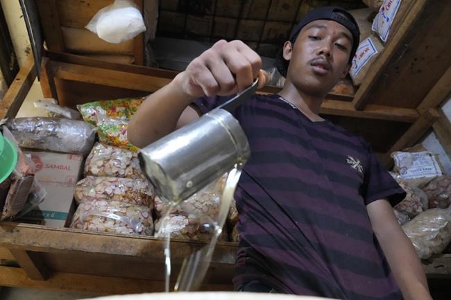 A vendor pours cooking oil into a container at a market in Jakarta, Indonesia, Sunday, April 17, 2022. Global cooking oil prices have been rising since the COVID-19 pandemic began and Russia's war in Ukraine has sent costs spiralling. It is the latest fallout to the global food supply from the war, with Ukraine and Russia the world’s top exporters of sunflower oil. And it's another rising cost pinching households and businesses as inflation soars. (AP Photo/Achmad Ibrahim)
