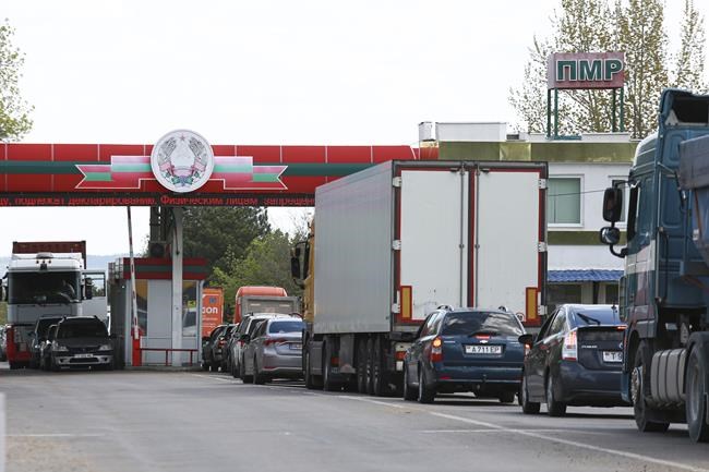 People wait in vehicles to cross the border seen from the Moldovan side of the Varnita-Bender crossing between Moldova and the Moldovan separatist region of Trans-Dniester, Tuesday, April 26, 2022. Police in the Moldovan separatist region of Trans-Dniester say two explosions on Tuesday morning at a radio facility close to the Ukrainian border knocked two powerful antennas out of service just a day after several explosions believed to be caused by rocket-propelled grenades were reported to have hit the Ministry of State Security in the city of Tiraspol, the region's capital. (AP Photo/Aurel Obreja)