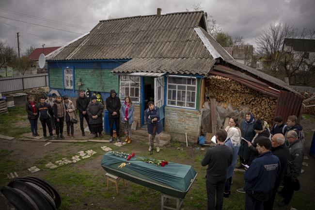 Relatives of Mykola Moroz, 47, gather during a funeral service at his home at the Ozera village, near Bucha, Ukraine, on Tuesday, April 26, 2022. Mykola was captured by Russian army from his house in the Ozera village on March 13, taken for several weeks in an unknown location and finally found killed with gunshots about 15 kilometres from his house. (AP Photo/Emilio Morenatti)