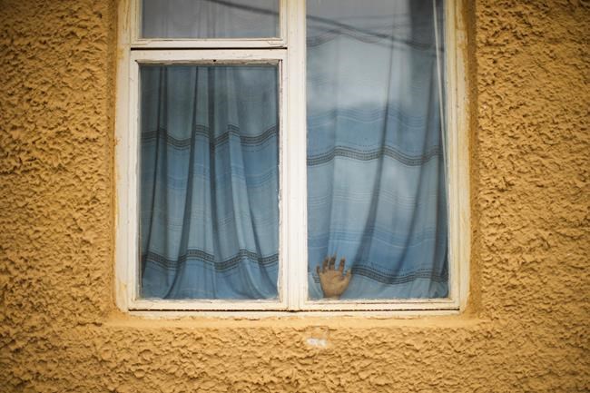 A plastic hand rests against a window in the 11th State Fire and Rescue Unit station in Chernobyl town, Ukraine, Tuesday, April 26, 2022. (AP Photo/Francisco Seco)